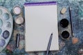 Creative space. The working space of the artist on the shabby table: paint gouache, notebook, pencils Royalty Free Stock Photo