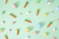 Creative Spring Easter concept on pastel mint background. Painted eggs and carrots. Flat lay Royalty Free Stock Photo