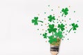 Creative St. Patricks Day concept. Paint brush with green glitter shamrocks and confetti. Minimal St. Patricks Day background