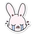 A creative sticker of a cartoon crying bunny face