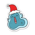A creative sticker cartoon of a germ wearing santa hat