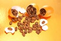 Creative still life of coffee beans emerging from a broken egg on a gold background, with eggshell pieces, blending surrealism and Royalty Free Stock Photo