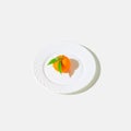 Creative still life composition made of fresh orange mandarin fruit on a plate on white background with shadow. Minimal style. Royalty Free Stock Photo