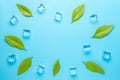 Creative summer composition with lemon leaves and ice cubes on blue background. Minimal drink concept Royalty Free Stock Photo