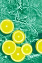 Creative summer composition made of sliced lemon in green transparent water. Refreshment concept. Healthy refreshing drink theme. Royalty Free Stock Photo