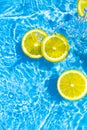 Creative summer composition made of sliced lemon in transparent blue water. Refreshment concept. Healthy refreshing drink theme. Royalty Free Stock Photo