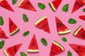 Creative summer food concept. Watermelon pattern. Juicy slices of ripe red watermelon and mint leaves on pink background. Flat lay
