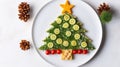 Creative table setting for the holiday, a Christmas tree made of food. Cucumbers, Tomatoes, greens and a star of cheese Royalty Free Stock Photo