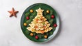Creative table setting for the holiday, a Christmas tree made of food. Omelet with tomatoes and cheese on a green plate Royalty Free Stock Photo