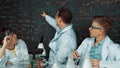 Creative teacher pointing at blackboard while talking to smart boy. Edification. Royalty Free Stock Photo