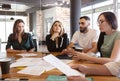 Creative team of four diverse pensive young business people gathered for weekly meeting in office Royalty Free Stock Photo