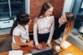 Creative team working on new project together looking and listening to their partner standing around desk using portable Royalty Free Stock Photo