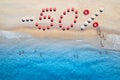 Creative text - 50 percent made from umbrellas on sandy beach