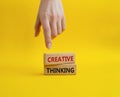 Creative thinkig symbol. Wooden blocks with words Creative thinkig. Businessman hand. Beautiful yellow background. Business and