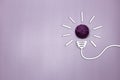 Creative thinking ideas and innovation concept. A purple color ball threads with a light bulb symbol on a violet