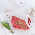 Creative Top view flat lay fresh raw beef meat striploin steak rosemary thyme herbs garlic pepper mushrooms meat white marble