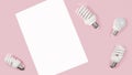 Creative top view flat lay of LED light bulbs and white paper mockup composition with copy space on pink background minimal style Royalty Free Stock Photo