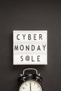 Creative Top view flat lay promotion composition Cyber Monday sale text on lightbox alarm clock white background copy space