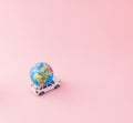 Creative travel concept with a car with a globe on it. Minimal summer composition aganist pastel pink background with copy space. Royalty Free Stock Photo