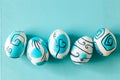 Creative trendy painted easter eggs on turquoise background