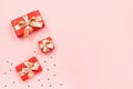 Creative Valentine`s Day greeting card with red decorations and gift boxes, golden heart confetti on pink background, copy space, Royalty Free Stock Photo