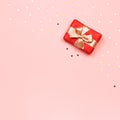 Creative Valentine`s Day greeting card with red decorations and gift boxes, golden heart confetti on pink background, copy space, Royalty Free Stock Photo