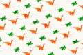 Creative wallpaper seamless pattern of rubber orange dinosaurs and green crocodiles on a light yellow background.