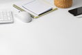 Creative white table with blank cellphone and supplies Royalty Free Stock Photo