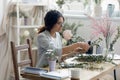 Creative woman florist arrange floral compositions at desk