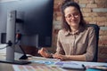 Creative woman, interior architect or designer working on a project, using computer while sitting at the desk in her Royalty Free Stock Photo