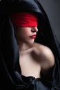 Woman portrait with red red blindfold and black satin covering head