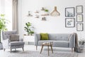 Creative, wooden pendant light above a gray sofa and a comfy arm