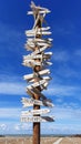 Creative, wooden signpost on the beach against the blue sky.