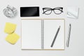 Creative workplace with open notebook, crumpled paper ball, post it notes, glasses, phone and pencils from above - vector Royalty Free Stock Photo