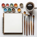 Creative workspace of an artist with paint, brushes, and an empty sketchbook Royalty Free Stock Photo