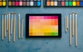 Creative workspace featuring digital tablet with colorful display, surrounded by paintbrushes and watercolor palette, showcasing Royalty Free Stock Photo