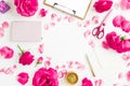 Creative workspace flat lay with roses, petals, notebook, scissors, and envelope on white background Royalty Free Stock Photo