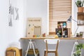 Creative workspace with scandinavian, wooden furniture, white walls and sewing tools in a modern crafts room interior. Real photo.