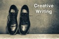 Creative Writing on brown board and work shoes on wooden floor