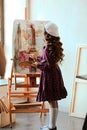 Creative young artist paints a colorful still life painting. Closeup of a painting process in an art workshop. Positive girl