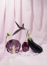 Creatively arranged eggplant and purple cabbage against light violet background