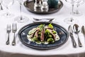 Creatively cooked beef flank steak with spinach gnocchi served on a ceremonially prepared table in the hotel restaurant
