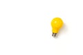 Yellow lightbulb against white background