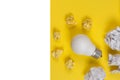 Creativity inspiration, great business idea concept with white light bulb and paper crumpled ball on yellow background. Royalty Free Stock Photo