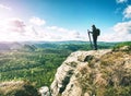 Creator and photographer is setting up tripod for standing on rock