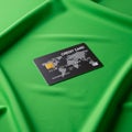 A credit card placed on smooth, bright green fabric. The card design includes a world Royalty Free Stock Photo