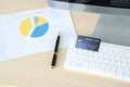 Credit card ready for payment on the keyboard and different graphs on paper Royalty Free Stock Photo