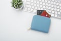 Credit card in wallet on computer keyboard on white background Royalty Free Stock Photo