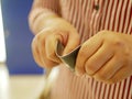 A credit card in a woman`s hands being folded and destroyed - breaking free of financial bondage