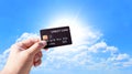 Credit cards and financial privileges concept, hand holding luxury credit card with sunlight and blue sky background